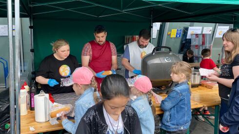 Olga Tsoi (left) helps distribute meals to refugees from Ukraine at a facility in Krakow, Poland.