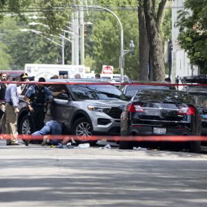 Officers investigate at the scene where a person was shot during a standoff with police Friday morning in the 100 block of South Kilpatrick Avenue.