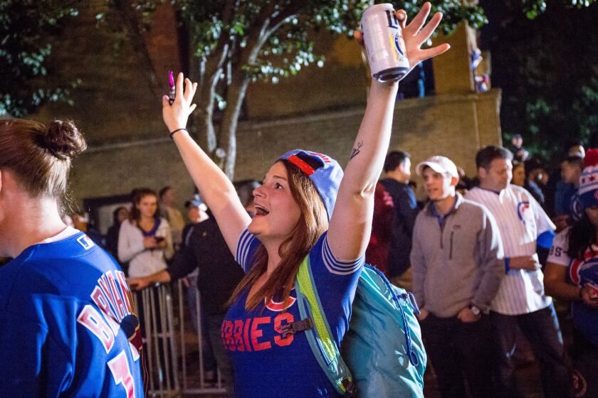 Fans celebrate the Cubs’ win outside Wrigley Field. | Santiago Covarrubias / Sun-Times