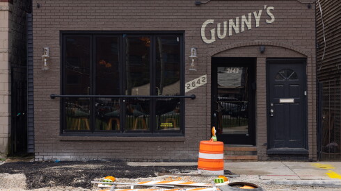 A construction cone sits on the closed street in front of Gunny's Pub in Lincoln Park.
