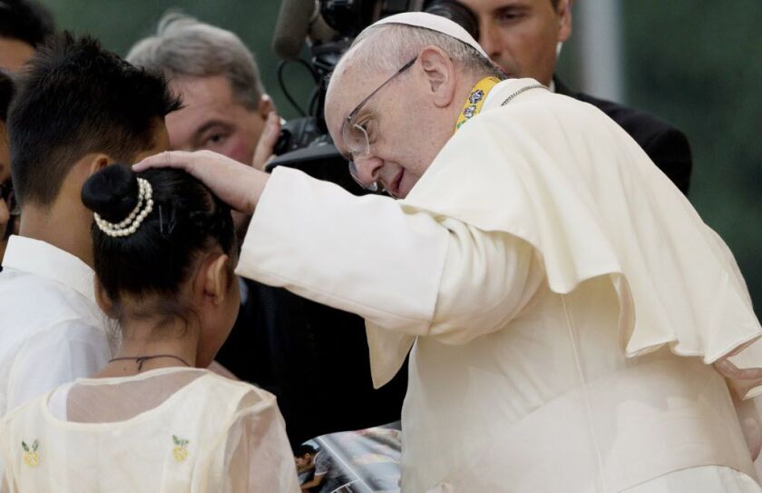 Pope Francis caresses 12-year-old Glyzelle Palomar, a rescued street child during his meeting with youths in Santo Tomas University in Manila, Philippines on Sunday. The pope ditched his prepared remarks and spoke off the cuff in his native Spanish to res