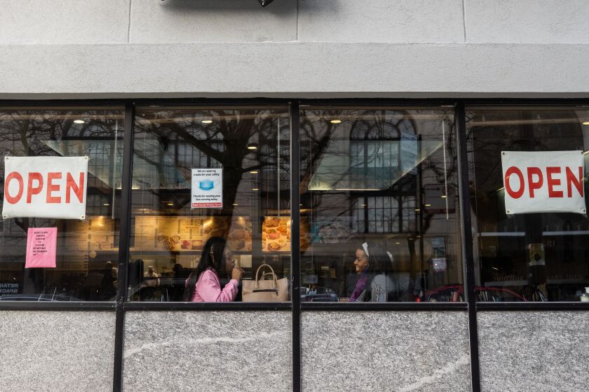 Mercedes Norris, right, and Lashel Norris, center, eat at Valois Cafeteria in the Hyde Park neighborhood Saturday. Suburban Cook County and Chicago moved back to Tier 1, which allows restaurants and bars to serve limited numbers of diners indoors.
