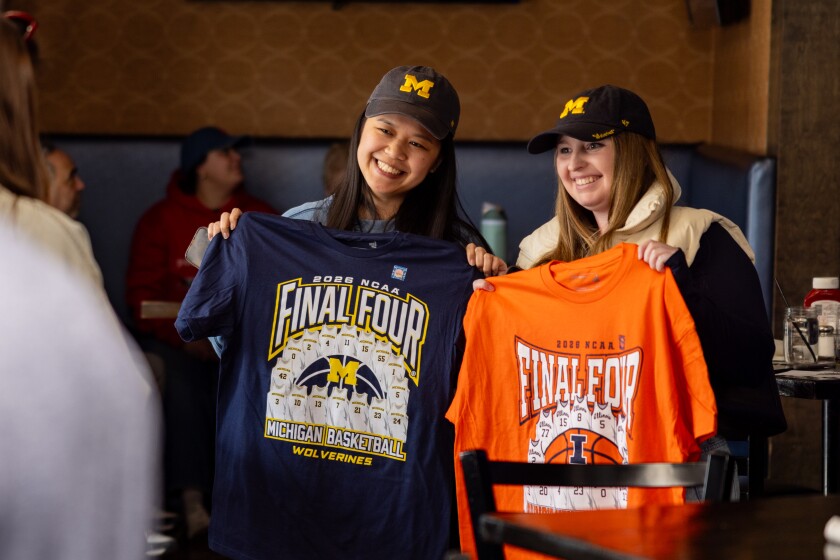 Michigan fans take a photo of their “Final Four” T-shirts purchased at Duffy's Tavern in Lincoln Park, during a March Madness viewing party.
