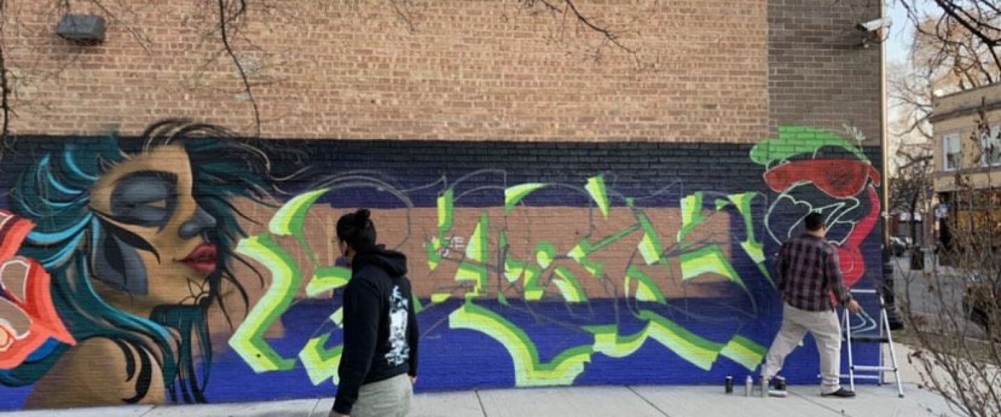 Street artists Josh “Classics” (left) and “Fresco” work on the mural at Quiroga’s Detail & Hand Car Wash, 3389 N. Milwaukee Ave.