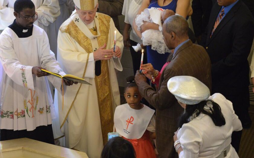 Marlee Palmer, 5, looks up after Archbishop Balse Cupich baptized her at St. Ailbe. | Brian Jackson/For the Sun-Times