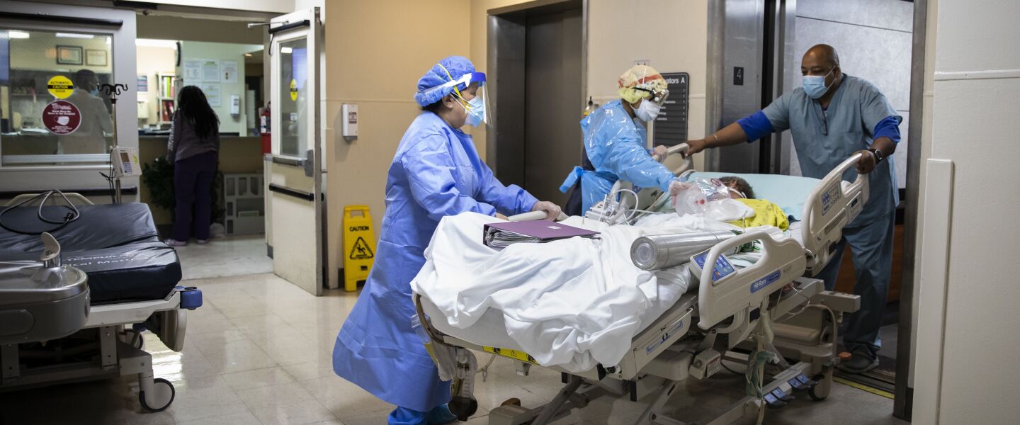 A patient is wheeled out of the Intensive Care Unit at Roseland Community Hospital on the Far South Side in December of 2020.