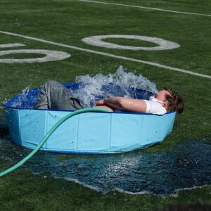 A student jumps into a wading pool filled with snow and water for St. Patrick High School’s version of the Polar Plunge.