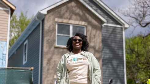 A woman wearing sunglasses stands in front of a newly-constructed home in Roseland.