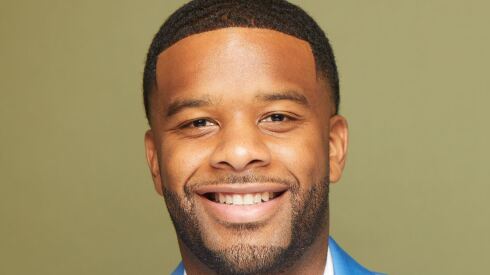 Ross Mac wears a white shirt and blue jacket.