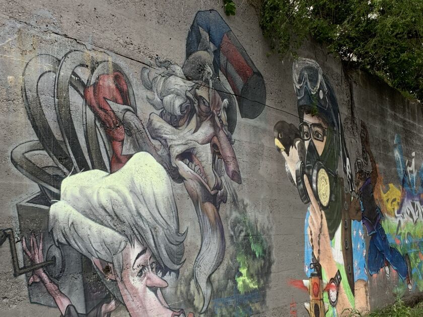 Pilsen artist Jesse Navarrete did this mural on the left, which he calls “Allegory of Corruption,” as a statement about government corruption and also government’s “mismanagement of money.” The art also carries an environmental message, as Uncle Sam is “spewing out very toxic fumes.” The adjacent mural is by Abie Vasquez III.