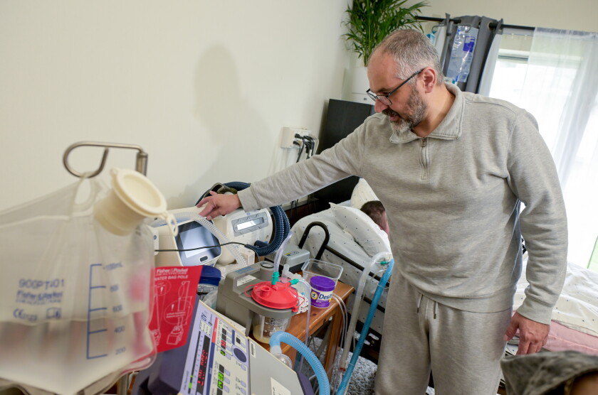 Mahmoud attends to some of the medical devices used by his disabled son Omar