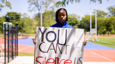 LJ Juarez holds a sign that reads: "You can't silence us."