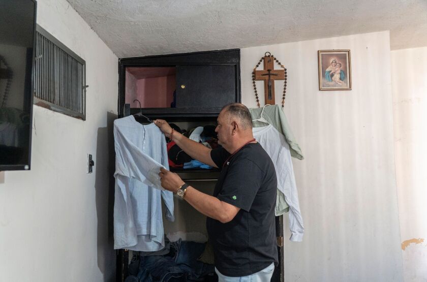 Gonzalez-Jaso holds up a shirt on a hanger.