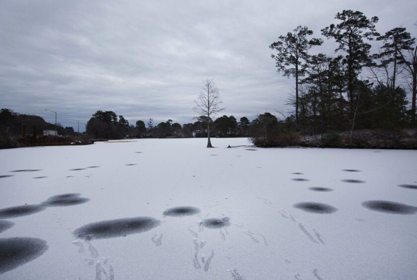 Snow covers the frozen water of Lake Smith in Virginia Beach, Va. on Wednesday. A brutal winter storm smacked the coastal Southeast with a rare blast of snow and ice Wednesday, hitting parts of Florida, Georgia and South Carolina with their heaviest snowf
