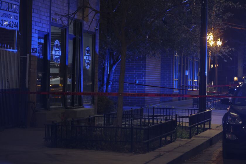 Police tape surrounds the scene where a 15-year-old boy was shot and killed, Wednesday, Nov. 24, 2021, near 2558 S Blue Island Ave in Heart of Chicago.