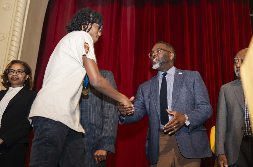 Chicago Mayor Brandon Johnson greets a member of the Marshall Commandos during a celebration for them at John Marshall Metropolitan High School in East Garfield Park, Thursday, April 2, 2026. The team won the won the Illinois High School Association Class 1A state championship in March.