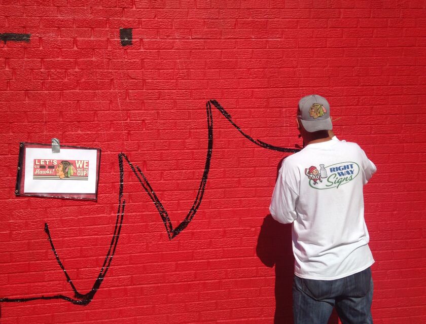 <small><strong>Ches Perry of Right Way Signs came to Chicago from Canada to attend an art school, but found out after arriving that it was a sign-painting school. On Tuesday, he was working on a Chief Blackhawk mural in Roscoe Village. | Mitch Dudek/Sun-T