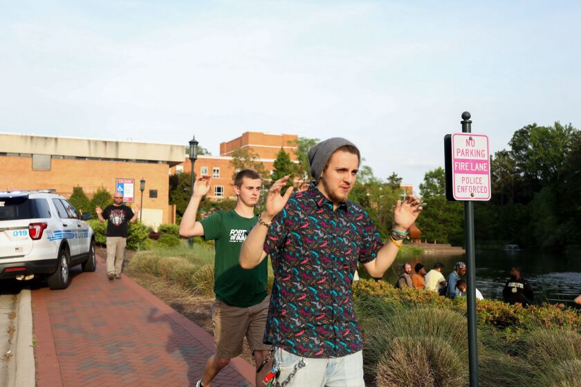 Students and faculty file out of buildings with their hands up during a lockdown after a shooting on the campus of University of North Carolina Charlotte in University City, Charlotte, on April 30, 2019. – Six people were shot, two of them died on the Uni