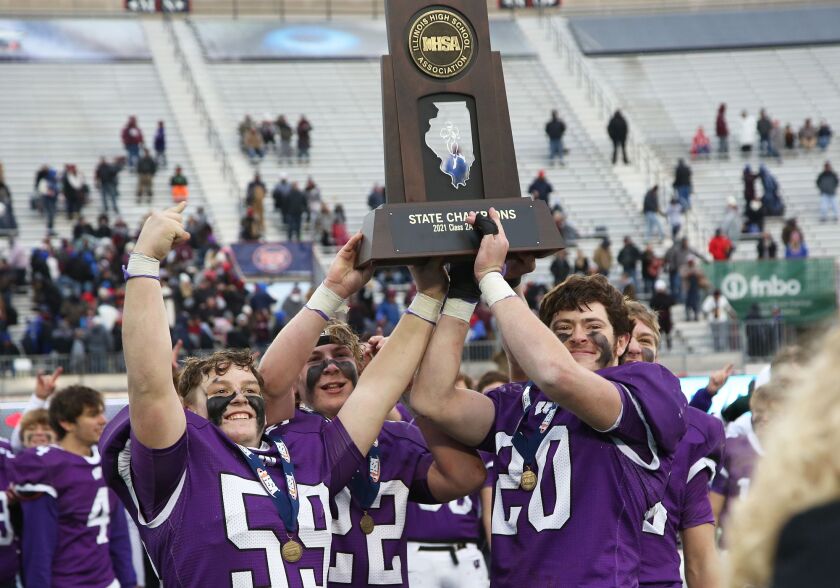 Wilmington’s captains Dominic Dingillo (59) and Allan Richards (20) hoist the IHSA 2A State championship trophy.