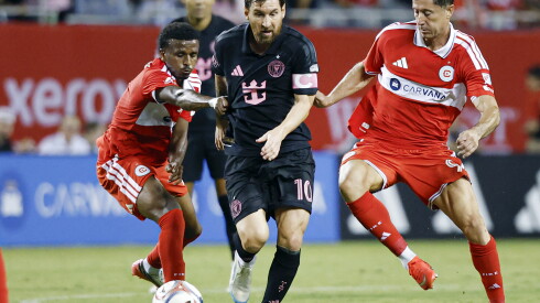 Lionel Messi, center, is defended by the Fire's Maren Haile-Selassie (left) and Robert Lewandowski.