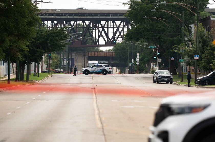 Police officers block off part of East 95th Street near South Escanaba Avenue in South Deering on the Far South Side on August 7, after 57 decomposing bodies were found in South Chicago Chapel, a funeral home, the night before.