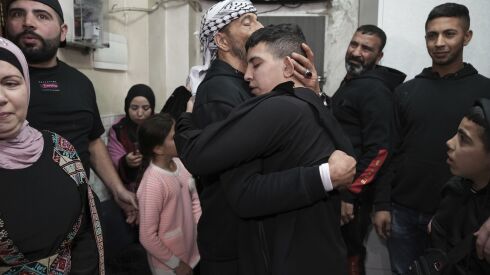 Ahmed Salaima, 14, center, a Palestinian prisoner released by Israel, is hugged by his father as he arrives home in the east Jerusalem neighborhood of Ras al-Amud on Nov. 28, 2023.