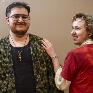 Bobby Robins (right), who is wearing a beret designed by Kimberly Porter and knitted by Robins, and Jay Shandilay, who is wearing a crocheted cardigan, smile during the 19th YarnCon at the Plumbers Union Hall in the Near West Side on Saturday.