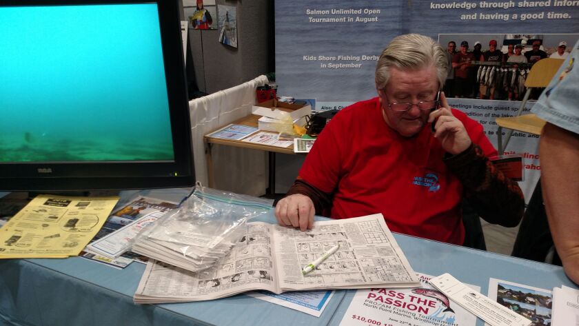OK, I could not resist taking taking this photo of Mike Mayworm reading the Sun-Times while working the Salmon Unlimited booth at the Chicagoland Fishing, Travel & Outdoor Expo at the Schaumburg Convention Center.<br>Credit: Dale Bowman