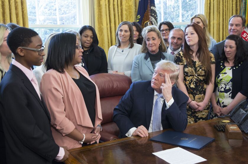 Yvonne Ambrose of Chicago talks to President Donald Trump on April 11, 2018, before he signed a bill intended to curb sex trafficking. To Ambrose’s right is her son, Keionte Abron. Ambrose’s daughter was killed after a pimp offered her up on Backpage.com