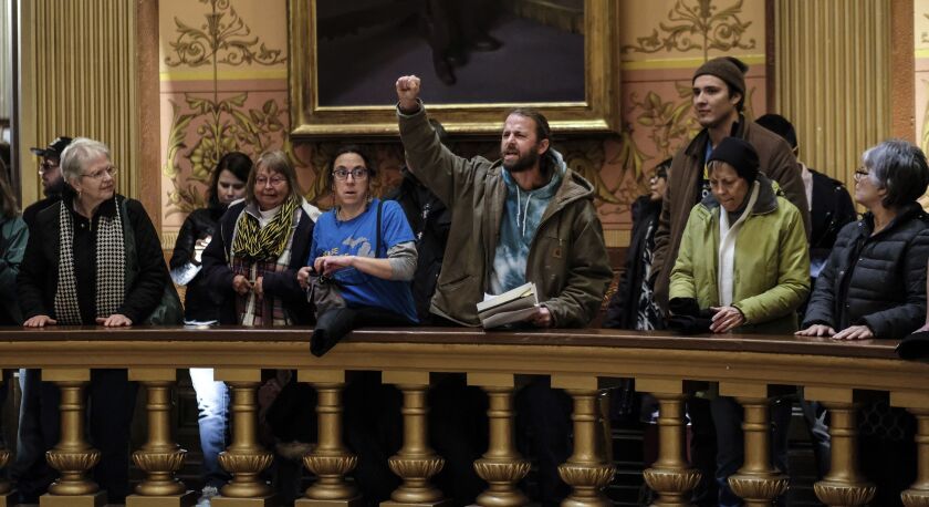 In this Tuesday, Dec. 4, 2018, photo, people take turns speaking to protest the lame duck legislation in the Capitol Rotunda in Lansing, Michigan. | Robert Killips/Lansing State Journal via AP