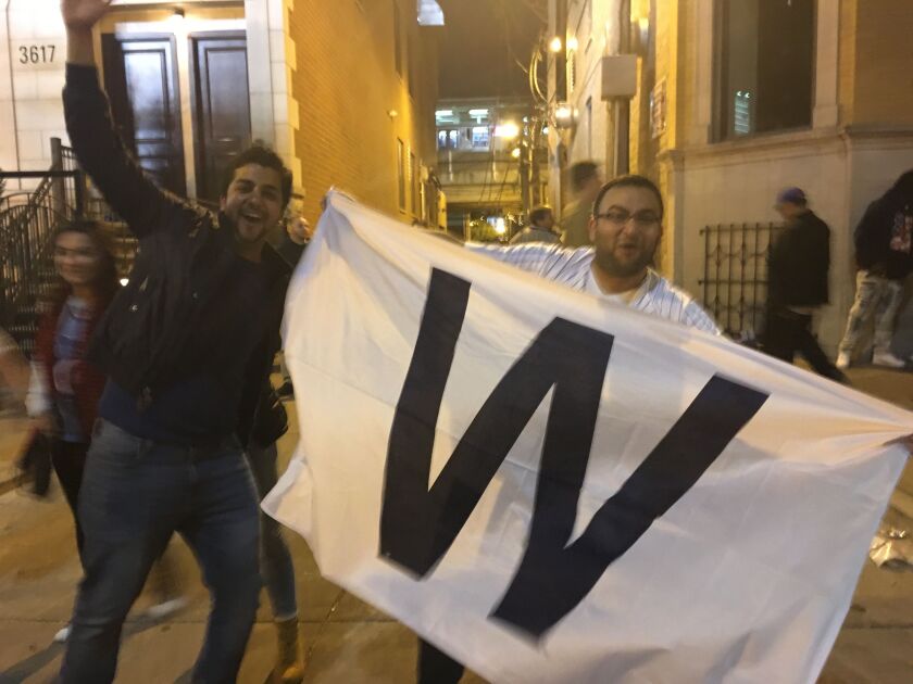 Adnan Vaince (left) and Muhammad Vaince “fly the W” after the Cubs won Saturday. | Jacob Wittich / Sun-Times