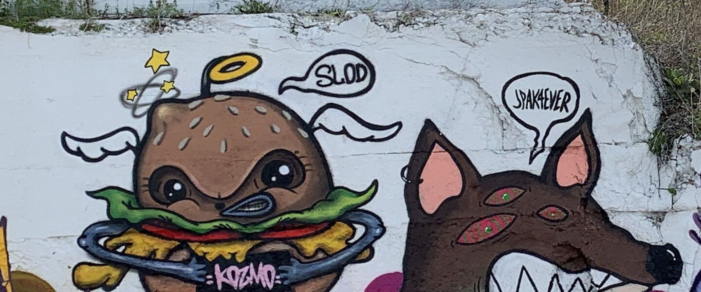KOZMO’s burger character with arms and legs stands next to the “fox demon” of Avondale artist Jeff Pak — who goes by JPAK4EVER. The “fox demon” was inspired by a manga that Pak read called “Chainsaw Man.”