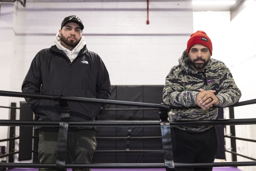Antonio Beniquez (left) and David Ortiz (right) founders of The Barracks Boxing Club stand inside the ring at the Northwest Side-based gym, where at-risk youth from nearby neighborhoods have been able to access free training through funding from the Puerto Rican Cultural Center.