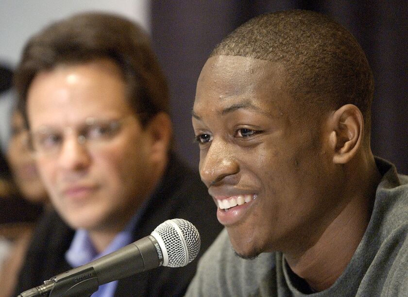 Marquette coach Tom Crean looks on Dwyane Wade announces his availability for the NBA draft in 2003.