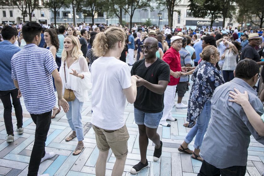 Josh Hills (center) and Peter Franco dance salsa as Orquesta El Macabeo performs during Chicago SummerDance, part of Taste of Chicago in Grant Parks Spirit of Music Garden on Saturday night, July 8, 2017. | Ashlee Rezin/Sun-Times