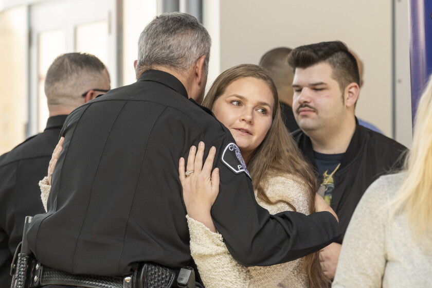 Family members of slain Michael and John Fields hug Cicero police officers after a press conference about the arrest of Daniel Flores who has been wanted for the 1995 slaying of Michael and John, at Cicero town hall, Friday, April 11, 2025.