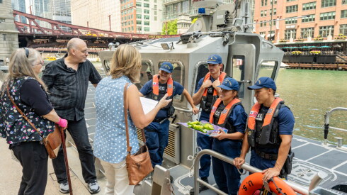 Barbara Decker Wachholz, a co-founder of the Eastland Disaster Historical Society, speaks with U.S. Coast Guard officers before a ceremony commemorating the victims of the S.S. Eastland disaster. The ceremony was held along the Chicago Riverwalk near the Clark Street bridge on Friday, July 24, 2026.