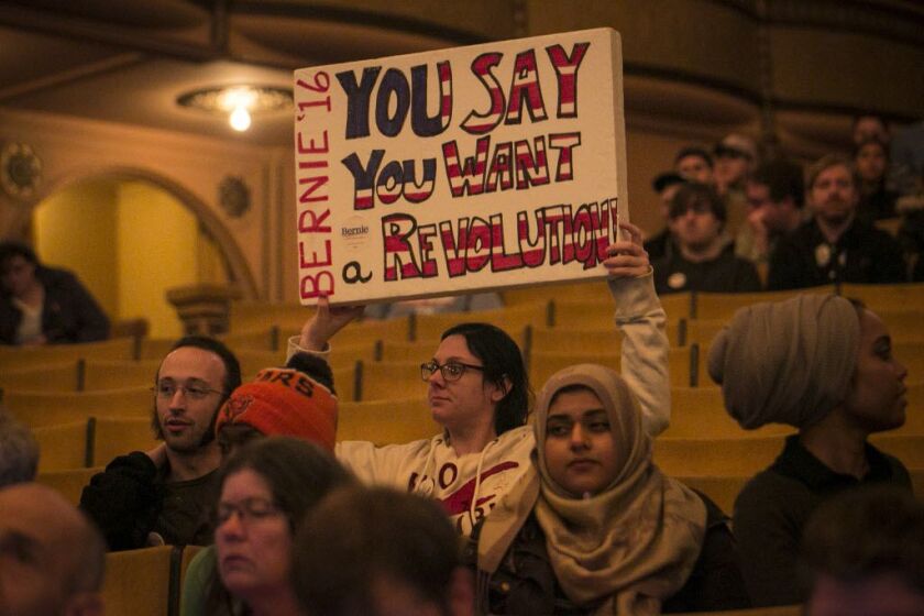 A Bernie Sanders’ backer hoists a sign in the Auditorium Theatre. | Ashlee Rezin/Sun-Times