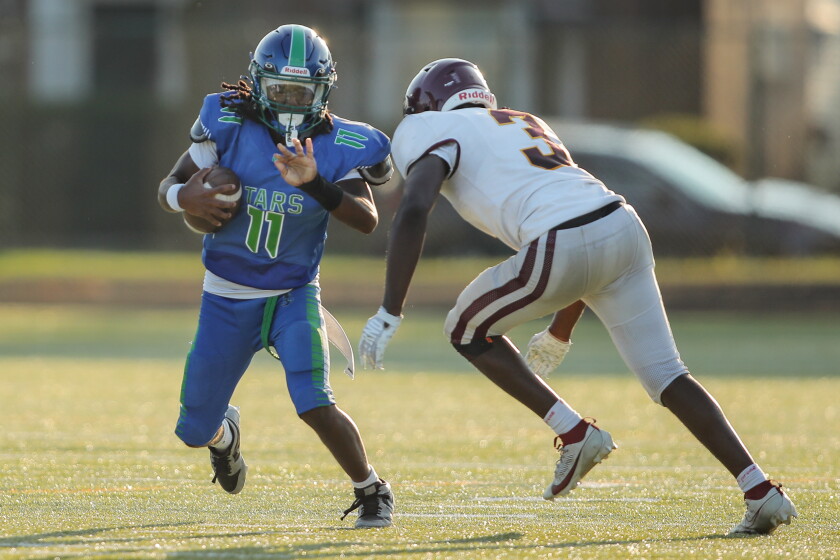 South Shore’s Zhyare Harris (11) carries the ball against Lindblom’s Jonathan Cole (3) during the game at Eckersall Stadium.