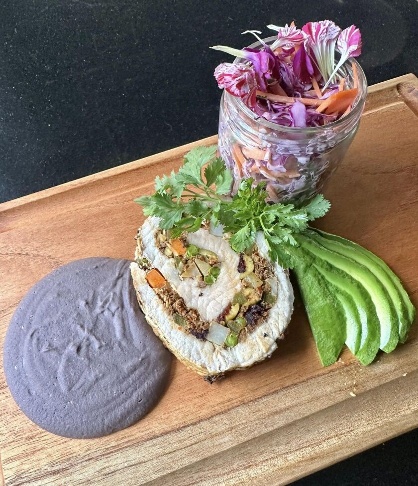 Stuffed pork tenderloin with creamy coleslaw and black bean puree.