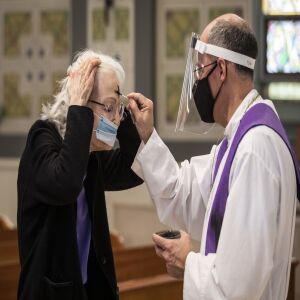 A congregant receives the imposition of ashes from Father Tom Hurley at Old St. Patrick’s Catholic Church on the Near West Side on Ash Wednesday, Feb. 17, 2021. Amid fears of the coronavirus pandemic, Hurley did not touch anyone and gave out ashes on a fresh Q-tip to each congregant, then threw the Q-tip away.
