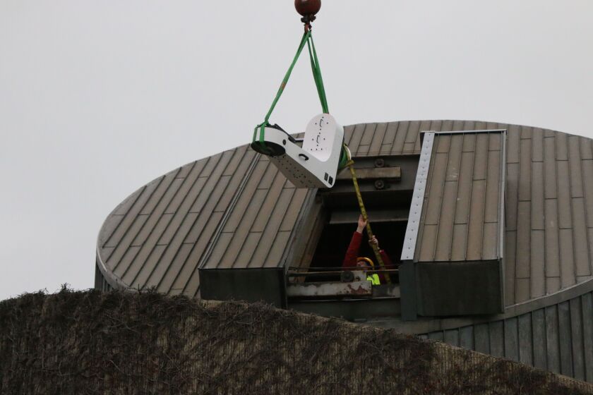 Workers using a crane to install a new, more powerful telescope, at The Adler Planetarium’s Doane Observatory. Jan. 28 2020.