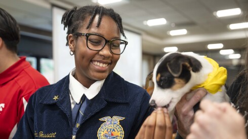 Jada Toussaint feeds her foster dog at the Chicago High School for Agricultural Sciences.