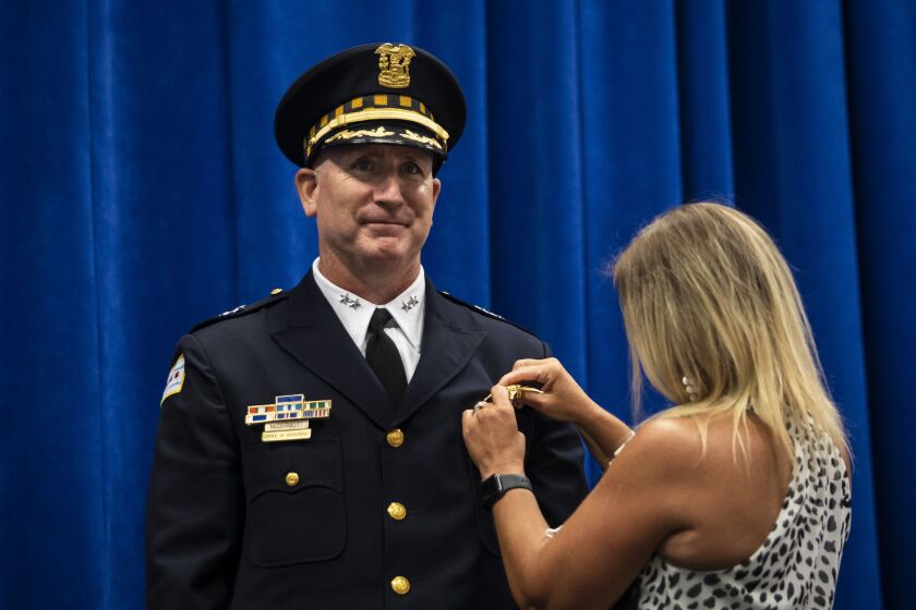Newly-promoted Chicago Police Department Chief of Operations Brian McDermott smiles as his wife affixes his new badge to his jacket during a ceremony at CPD headquarters, Wednesday morning, July 15, 2020. McDermott, a 25-year department veteran who previously served as commander of the Chicago Lawn District on the Southwest Side, replaces retiring Chief of Operations Fred Waller.