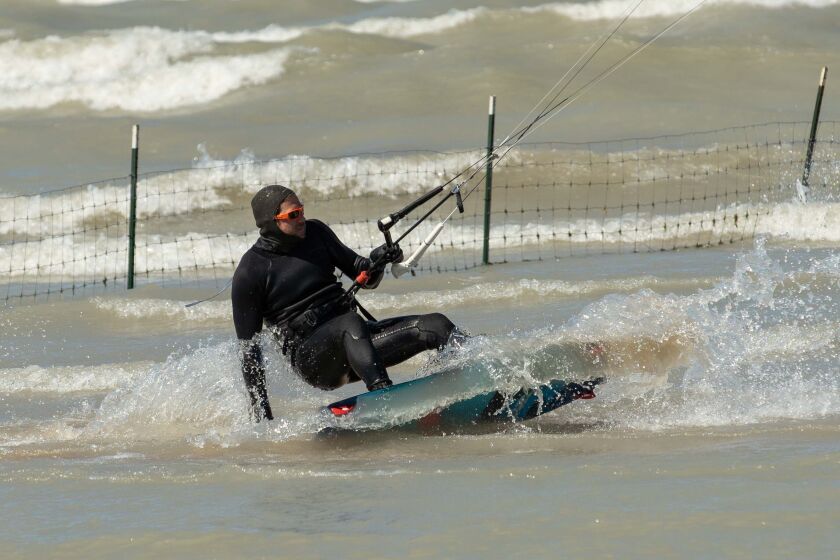 A windsurfer rides a wave Saturday at Montrose Beach in the Uptown neighborhood.