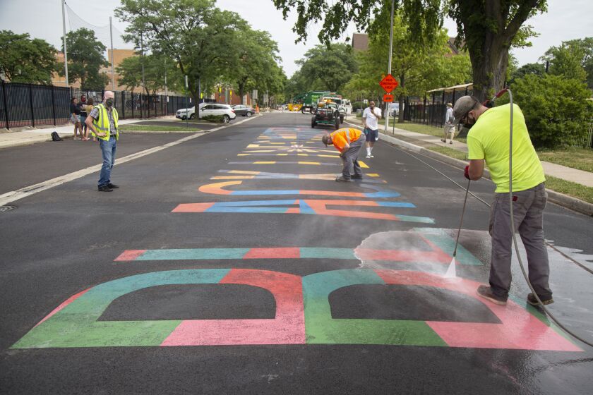 Village employees from the Department of Public Works clean off black paint from the Black Lives Matter mural after it was vandalized to read “All Lives Matter” near North Scoville Avenue and Lake Street in Oak Park, Wednesday afternoon, July 8, 2020.