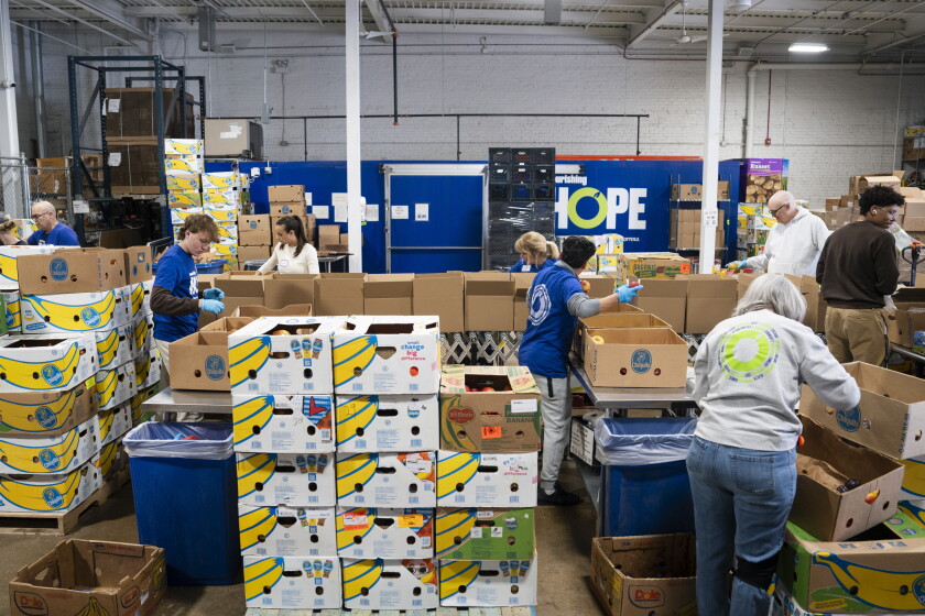 Volunteers pack food at Nourishing Hope in West Town, Friday, March 28, 2025.