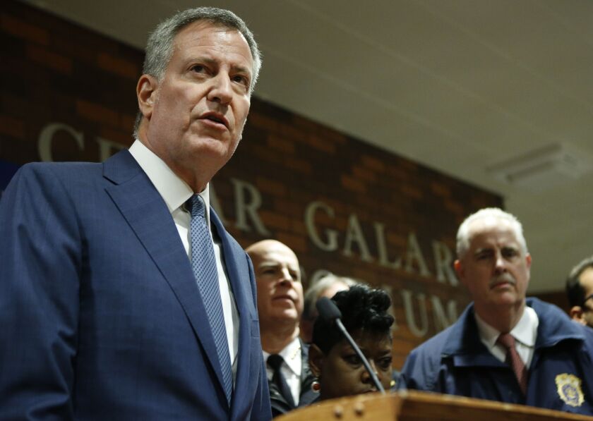 New York City Mayor Bill de Blasio (center) speaks at Lincoln Hospital on Thursday, Feb. 4, 2016, in the Bronx after two police officers were shot. NYPD chief of detectives Robert Boyce (right) listens. | Kathy Willens/AP