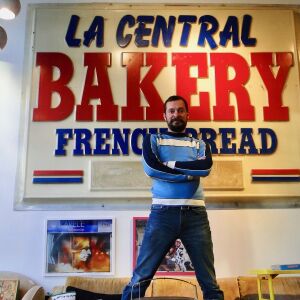 Chris Hunt, owner of Seek Vintage, 1433 W. Chicago Ave. in front of a salvaged bakery sign. | Alisa Hauser/For the Sun-Times