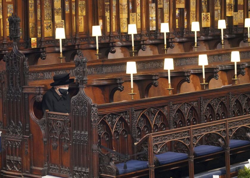 Britain’s Queen Elizabeth II sits alone in St. George’s Chapel during the funeral of Prince Philip, the man who had been by her side for 73 years, at Windsor Castle, Windsor, England, Saturday April 17, 2021.
